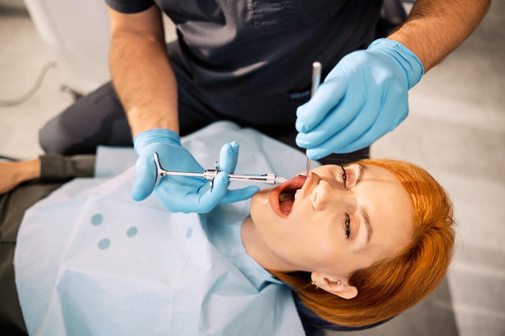 female patient getting painful dental injection
